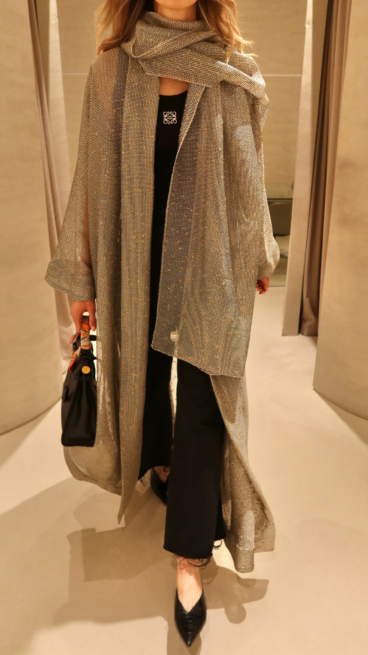 A model wearing the F.Lounge Shine Abaya, a minimalist everyday abaya in a soft neutral tone