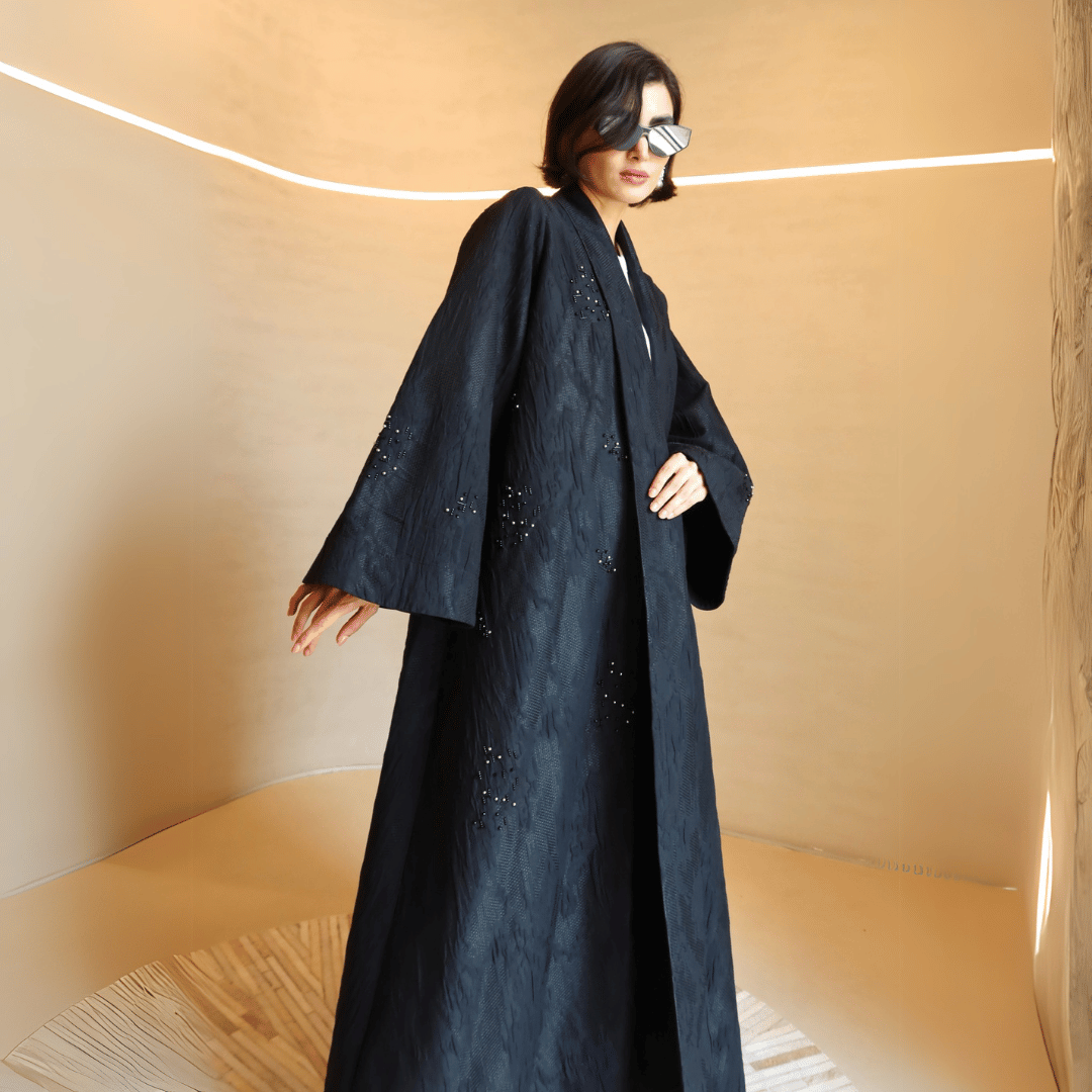 Woman wearing an elegant F.Lounge Stone Jacquard abaya styled for an evening occasion